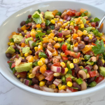 bean and veggie mix in a white bowl with silver spoon