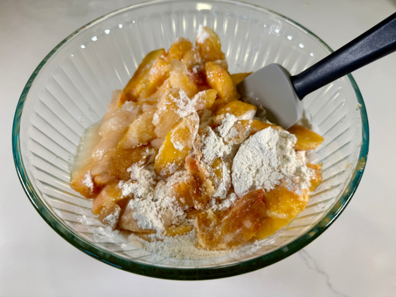 bowl full of peach filling being mixed with a spatula